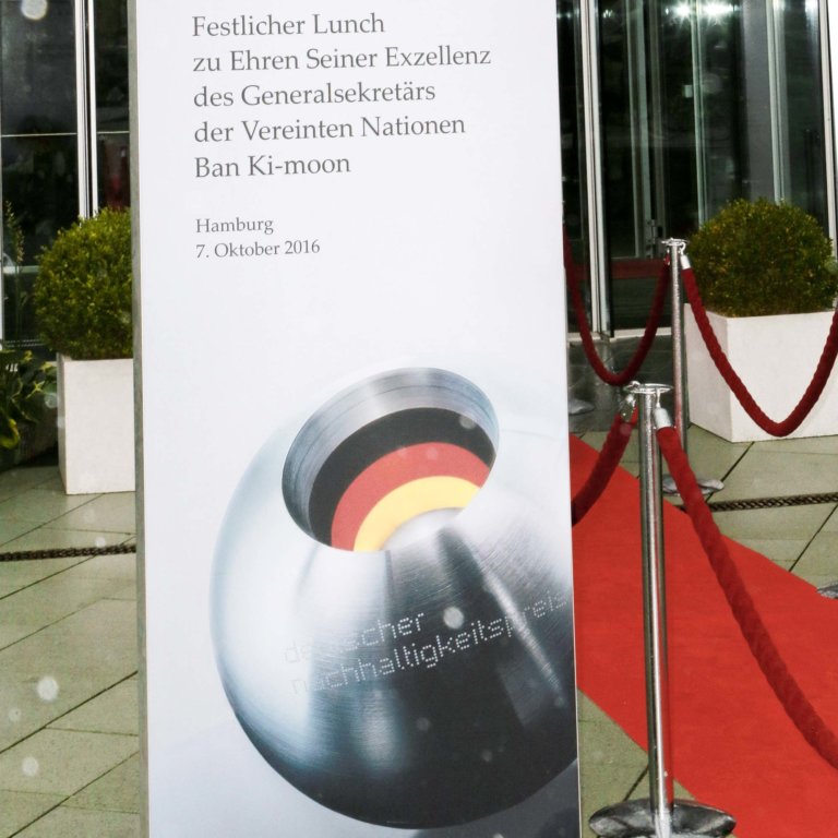 Entrance to event location with red carpet and large roll-up