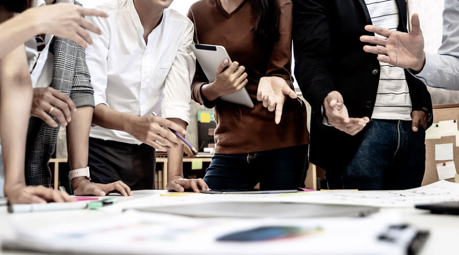 Effective event planning for unforgettable experiences with Schnell Event Services. A group of people stand around a table with planning documents.